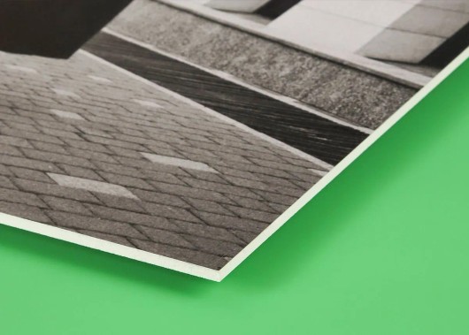Dezelfde dorpsfoto op forex van opzij, met zicht op de dunne, vlakke plaat
